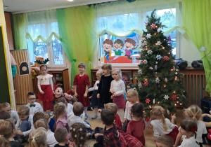 Na zdjęciu widać dzieci przy wspólnym kolędowaniu.