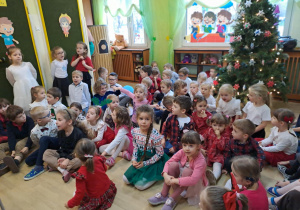 Na zdjęciu widać dzieci przy wspólnym kolędowaniu.