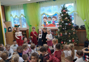 Na zdjęciu widać dzieci przy wspólnym kolędowaniu.