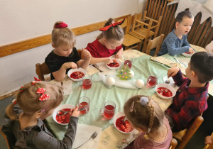 Na zdjęciu widać dzieci przy wspólnym kolędowaniu.