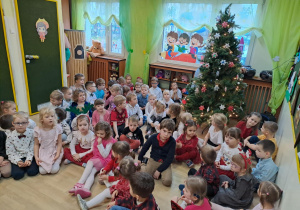 Na zdjęciu widać dzieci przy wspólnym kolędowaniu.