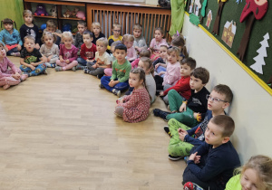 Na zdjęciu widać dzieci siedzące na podłodze które czekają na rozstrzygnięcie konkursu.