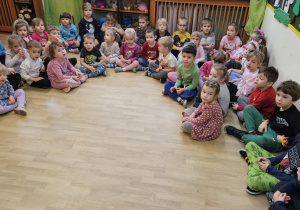 Na zdjęciu widać dzieci siedzące na podłodze które czekają na rozstrzygnięcie konkursu.