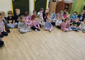 Na zdjęciu widać dzieci siedzące na podłodze które czekają na rozstrzygnięcie konkursu.