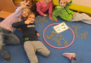 Na zdjęciu widać dzieci które piszą literę y,Y z makaronu.