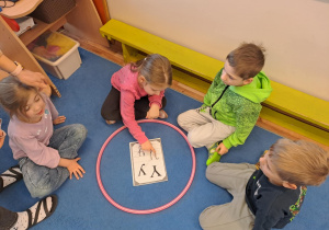 Na zdjęciu widać dzieci które piszą literę y,Y z makaronu.