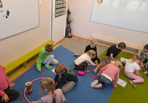 Na zdjęciu widać dzieci które piszą literę y,Y z makaronu.