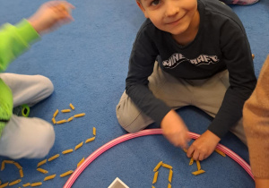 Na zdjęciu widać chłopca który pisze literę Y,y