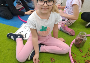 Na zdjęciu widać dziewczynkę która pisze literę y,Y z makaronu.