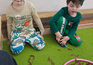 Na zdjęciu widać dzieci które piszą literę y,Y z makaronu.