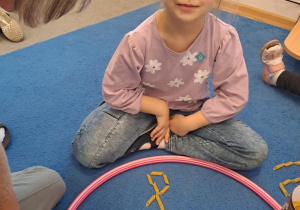 Na zdjęciu widać dziewczynkę która pisze literę y,Y z makaronu.