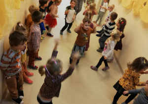 Dzieci tańczą, jeden chłopiec ma uniesione do góry ręce