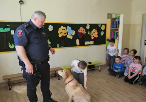 Na zdjęciu widać Pana z psem ze Straży Miejskiej oraz dziecko.