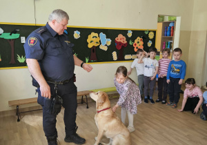 Na zdjęciu widać Pana z psem ze Straży Miejskiej oraz dziecko.