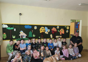 Na zdjęciu widać Pana z psem ze Straży Miejskiej oraz dzieci.