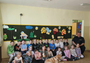 Na zdjęciu widać Pana z psem ze Straży Miejskiej oraz dzieci.