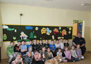 Na zdjęciu widać Pana z psem ze Straży Miejskiej oraz dzieci.