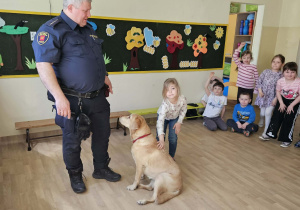 Na zdjęciu widać Pana z psem ze Straży Miejskiej oraz dziecko.