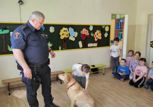 Na zdjęciu widać Pana z psem ze Straży Miejskiej oraz dziecko.