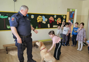 Na zdjęciu widać Pana z psem ze Straży Miejskiej oraz dziecko.
