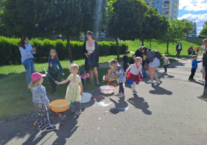 Na zdjęciu widać dzieci i rodziców na pikniku rodzinnym.