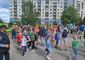 Na zdjęciu widać dzieci i rodziców na pikniku rodzinnym.