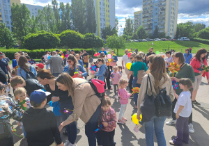 Na zdjęciu widać dzieci i rodziców na pikniku rodzinnym.