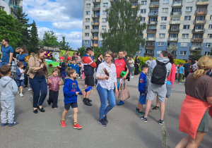 Na zdjęciu widać dzieci i rodziców na pikniku rodzinnym.