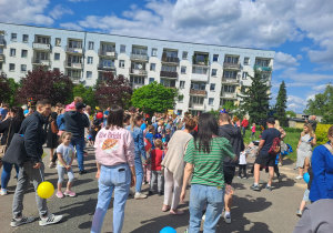 Na zdjęciu widać dzieci i rodziców na pikniku rodzinnym.