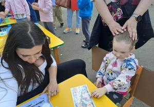 Na zdjęciu widać dzieci i rodziców na pikniku rodzinnym.