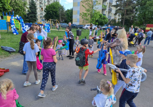 Na zdjęciu widać dzieci i rodziców na pikniku rodzinnym.
