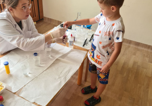 Na zdjęciu widać dzieci na warsztatach chemicznych.