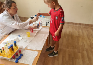Na zdjęciu widać dzieci na warsztatach chemicznych.