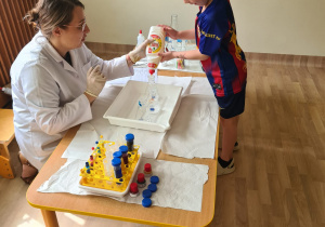 Na zdjęciu widać dzieci na warsztatach chemicznych.