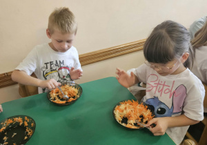 Na zdjęciu widać dzieci które przygotowują sałtakę.