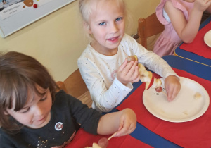 NA ZDJĘCIU WIDAĆ DZIECI KTÓRE ROBIĄ OWOCOWE SZASZŁYKI.