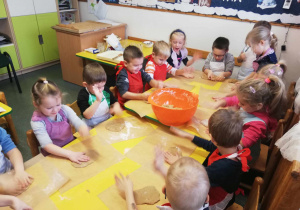 Dzieci uklepują ciasto piernikowe.