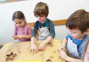 Dzieci odciskają kształt gwiazdki z ciasta piernikowego