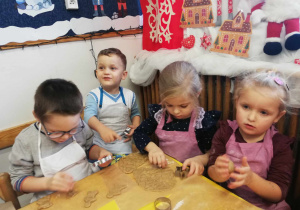 Dzieci odciskają kształty z ciasta piernikowego