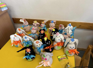 Dwadzieścia króliczków wykonanych przez dzieci jest ustawionych na stoliku.