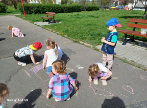 Dzieci rysują kredą na boisku