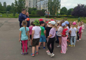 Dzieci stoją w grupce i słuchają co mówi trener