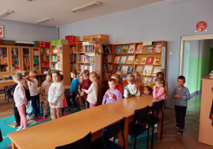 Na zdjęciu widać dzieci które znajdują się w bibliotece szkolnej.