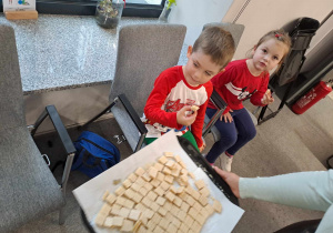 Na zdjęciu widać dzieci które konsumują miód w wafelkach.