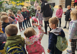 Na zdjęciu widać dzieci które oglądają jaszczurkę.