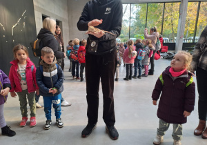 Na zdjęciu widać Pana który pokazuje dzieciom jaszczurkę.